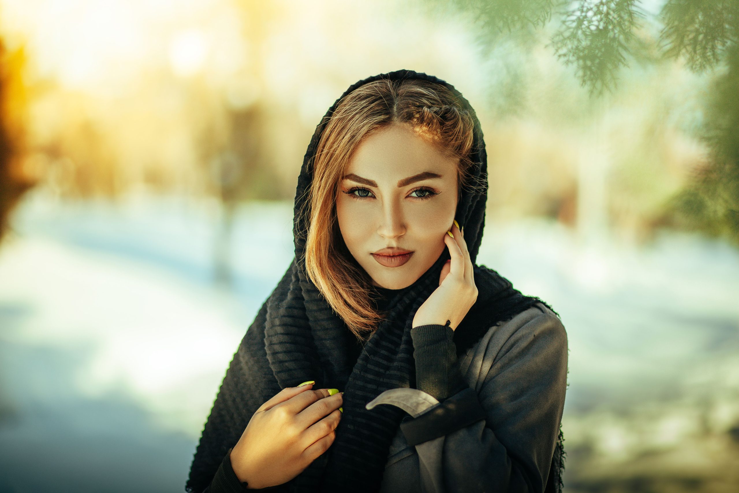 Portrait of a woman in black scarf standing outdoors in Tehran, showcasing elegance and style.