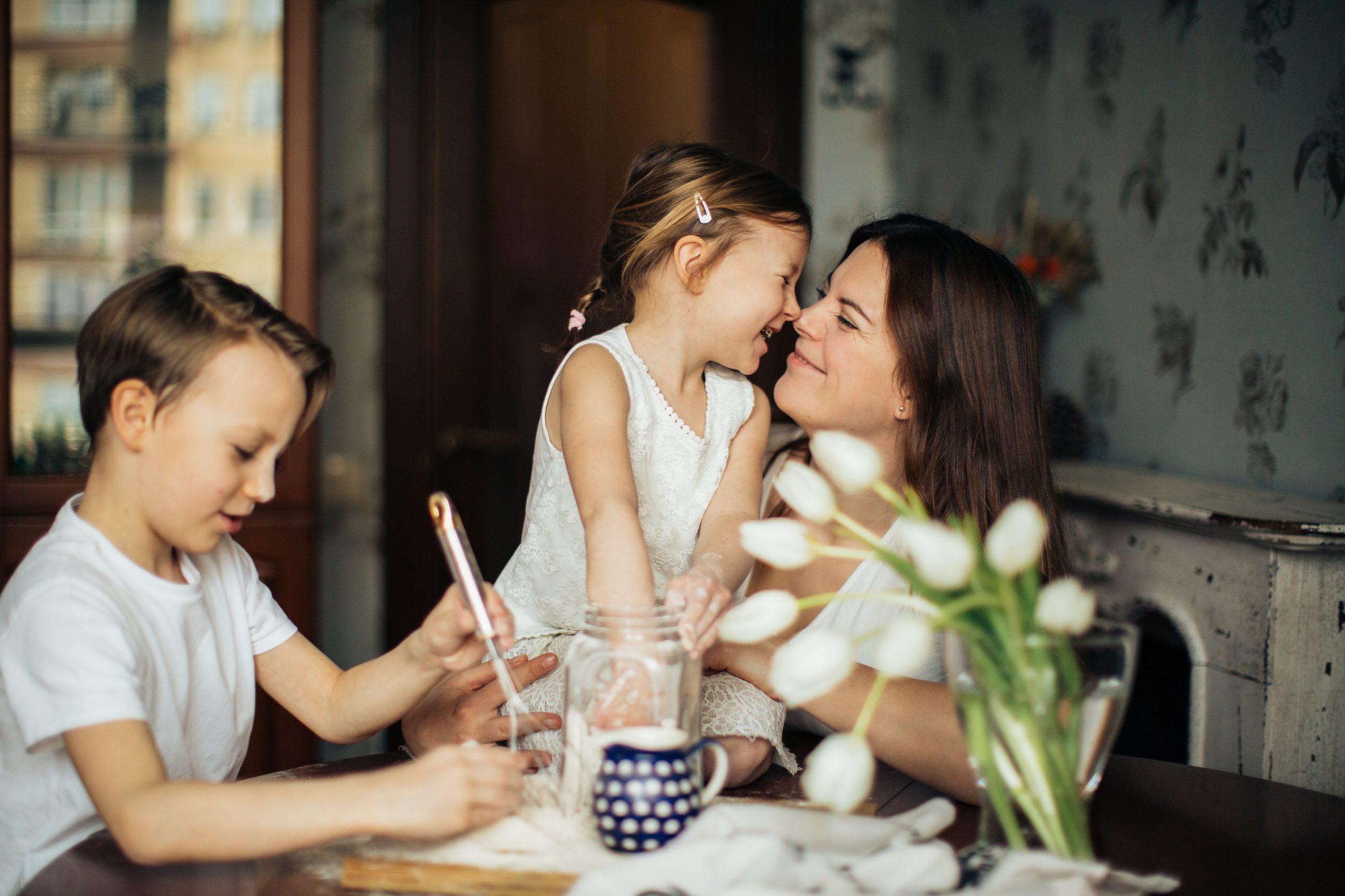 A joyful moment of a mother baking with her children in a cozy home environment.
